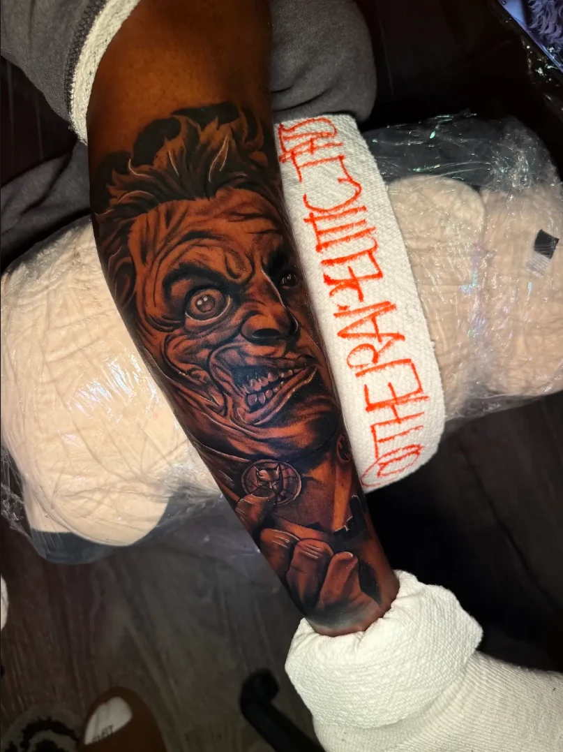 Detailed dramatic face tattoo on an arm by Hasan Ink